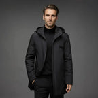 Man wearing a black coat against a gray background