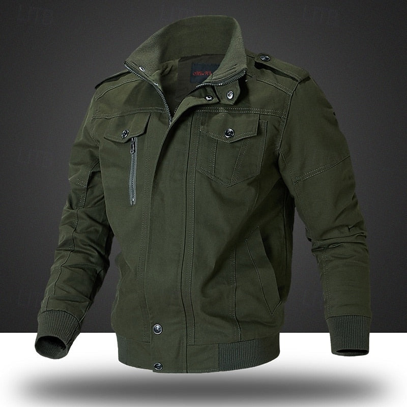An olive green men's utility jacket with a stand-up collar, button snap closure, zippered chest pocket, and ribbed cuffs and hem, shown on a dark gray background.