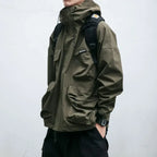 Person wearing a green jacket with a backpack on a plain background