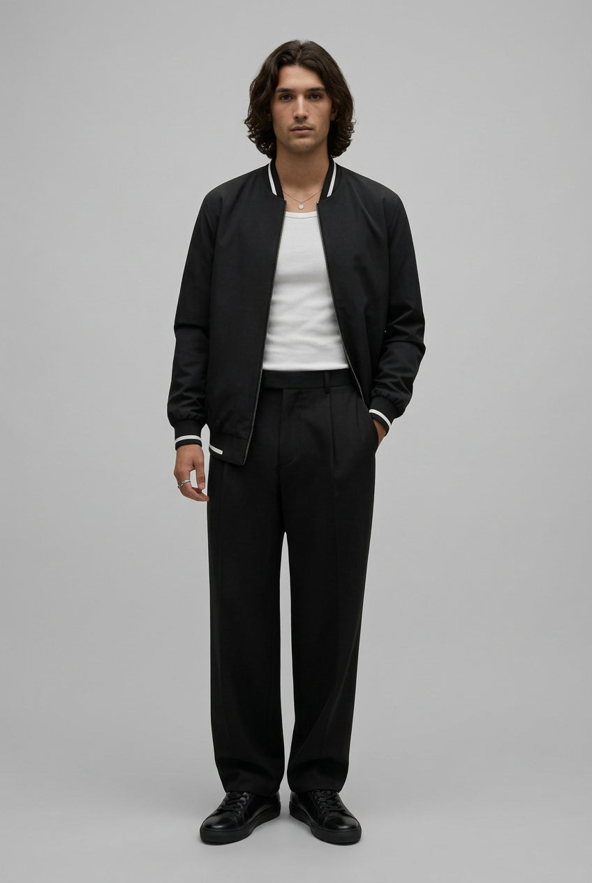 Man wearing a black jacket and black pants on a white background