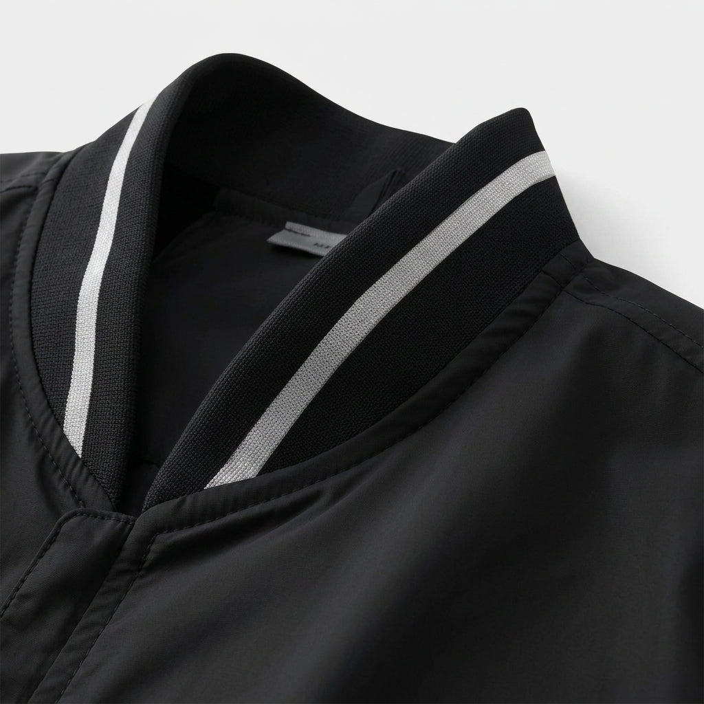 Close-up of a black garment with a white stripe on a light gray background