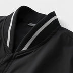 Close-up of a black garment with a white stripe on a light gray background