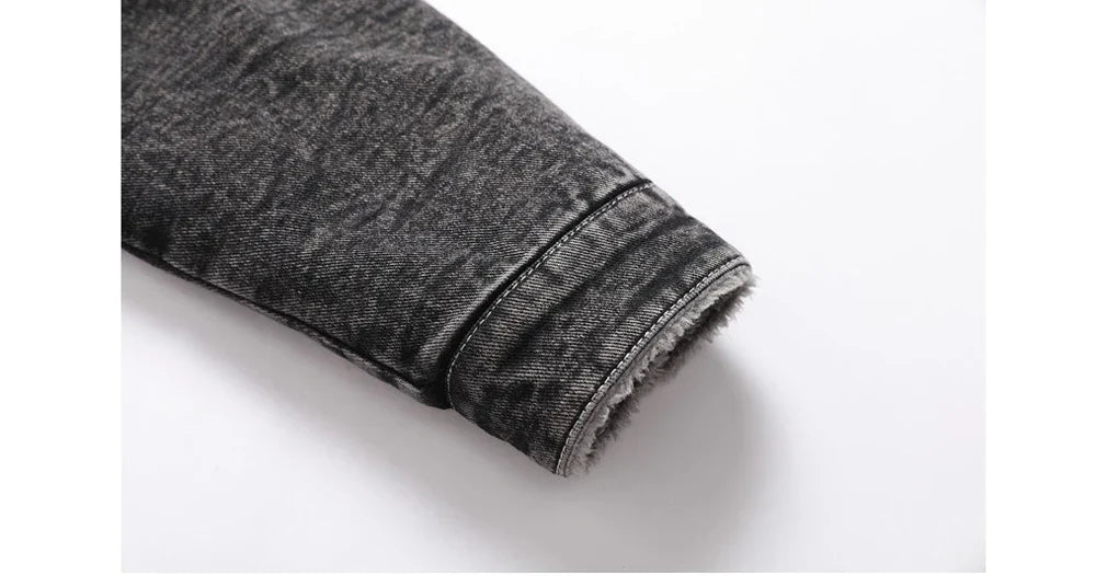 Close-up of a rolled-up black denim jeans cuff on a white background