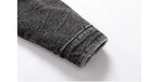 Close-up of a rolled-up black denim jeans cuff on a white background
