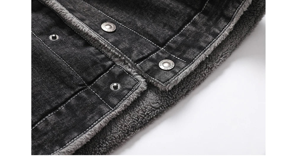 Close-up of a black denim jacket with silver buttons on a white background