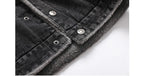 Close-up of a black denim jacket with silver buttons on a white background