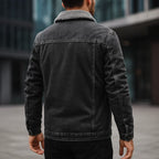 Person wearing a dark denim jacket with a blurred background