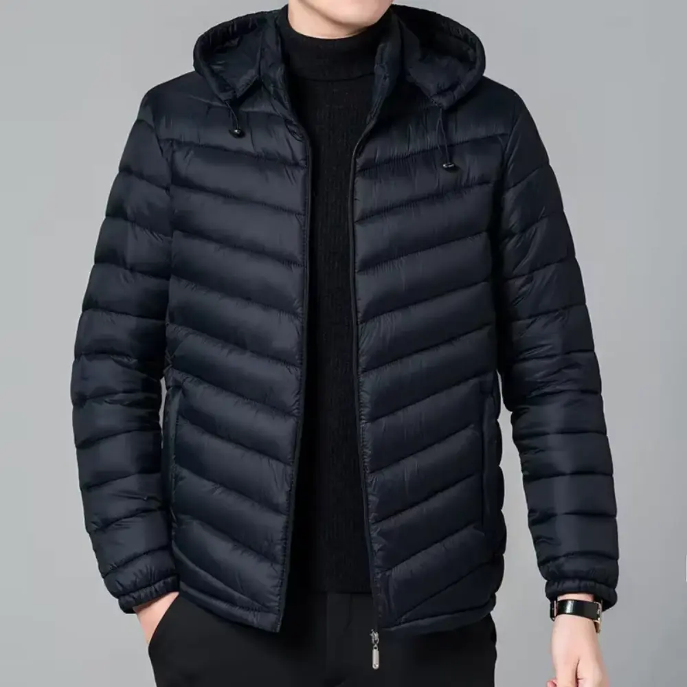 Black puffer jacket worn by a person on a gray background