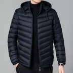 Black puffer jacket worn by a person on a gray background