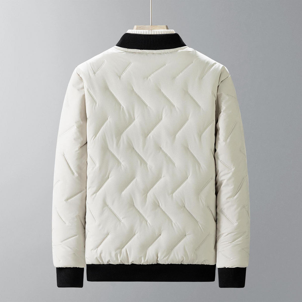 White quilted jacket with black trim on a gray background