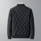 Black quilted jacket on a gray background
