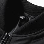 Close-up of a black jacket with a brand label on a white background