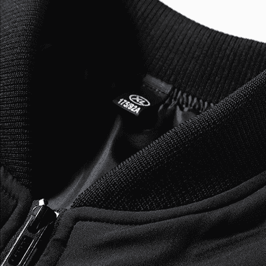 Close-up of a black jacket with a brand label on a white background