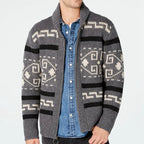 Person wearing a gray patterned cardigan over a blue shirt on a white background