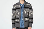 Person wearing a gray patterned cardigan over a blue shirt on a white background