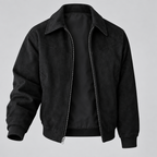 A black suede-textured zip-up jacket with a pointed collar, ribbed cuffs, and a ribbed hem, shown on a neutral light gray background.