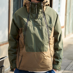 Green and brown jacket with a hood worn by a person, blurred background