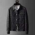 A men's dark gray suede or micro-suede jacket with a classic collar, button-up front, and flap chest pockets, displayed on a hanger over a white t-shirt against a dark gray gradient background.