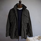 Dark green jacket on a mannequin against a plain background