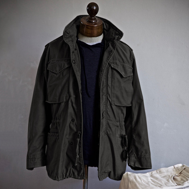 Dark green jacket on a mannequin against a plain background