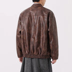 Brown leather jacket worn by a person on a white background