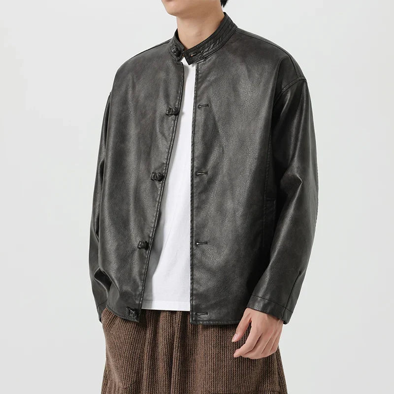 Person wearing a black leather jacket over a white shirt on a white background