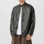 Person wearing a black leather jacket over a white shirt on a white background