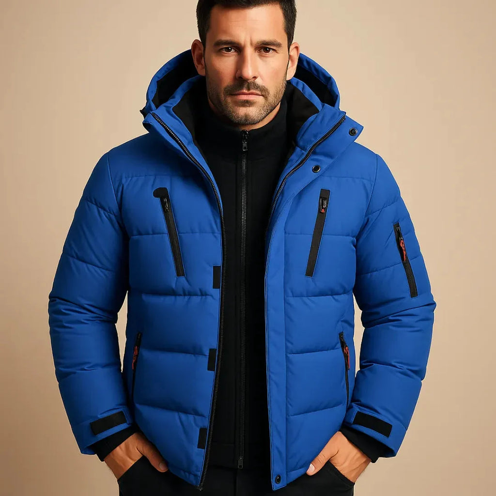 Man wearing a blue puffer jacket against a beige background