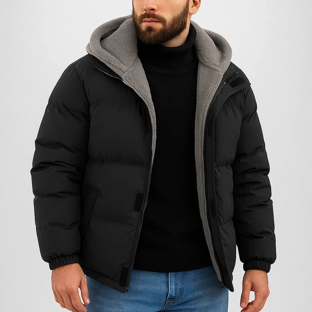 Man wearing a black puffer jacket with gray hood on a white background