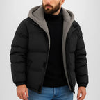 Man wearing a black puffer jacket with gray hood on a white background