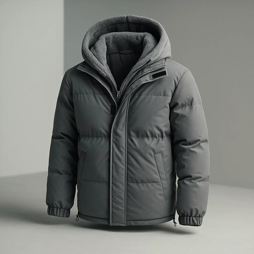A dark gray hooded puffer jacket with a soft fleece-lined hood, shown on a neutral gray background.