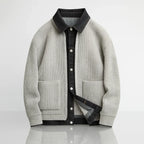 Gray ribbed sweater with black collar and buttons on a light gray background