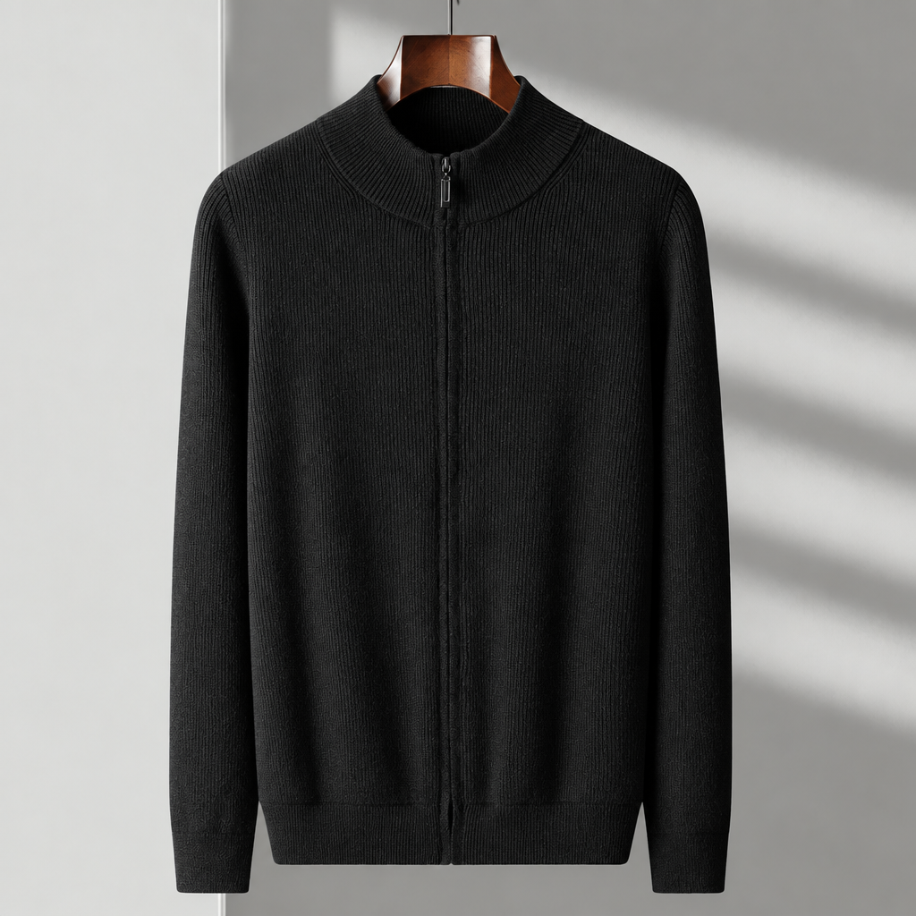 A black ribbed knit zip-up sweater with a mock neck collar, hanging on a wooden hanger against a light gray wall with soft diagonal shadows.