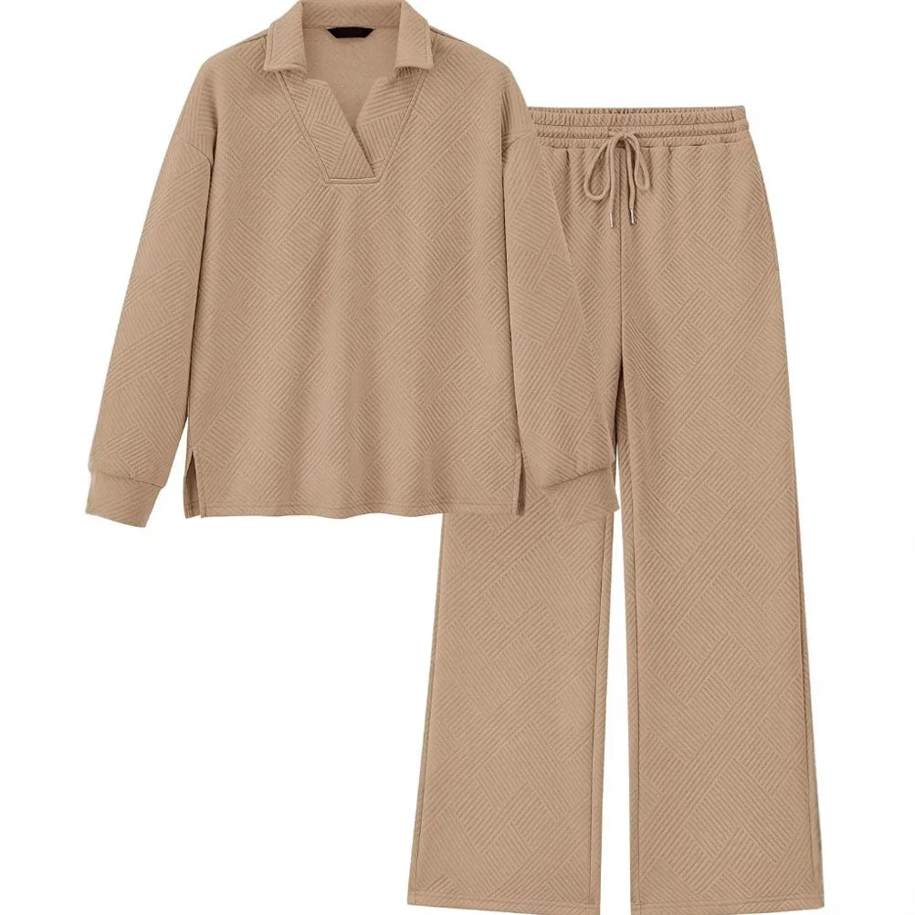 A two-piece lounge set in a warm beige color with a subtle textured herringbone pattern, featuring a long-sleeve polo-style top and matching drawstring pants, displayed on a solid white background.