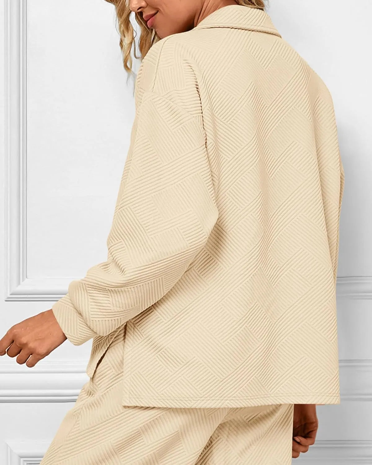 Beige cardigan worn by a person against a white wall