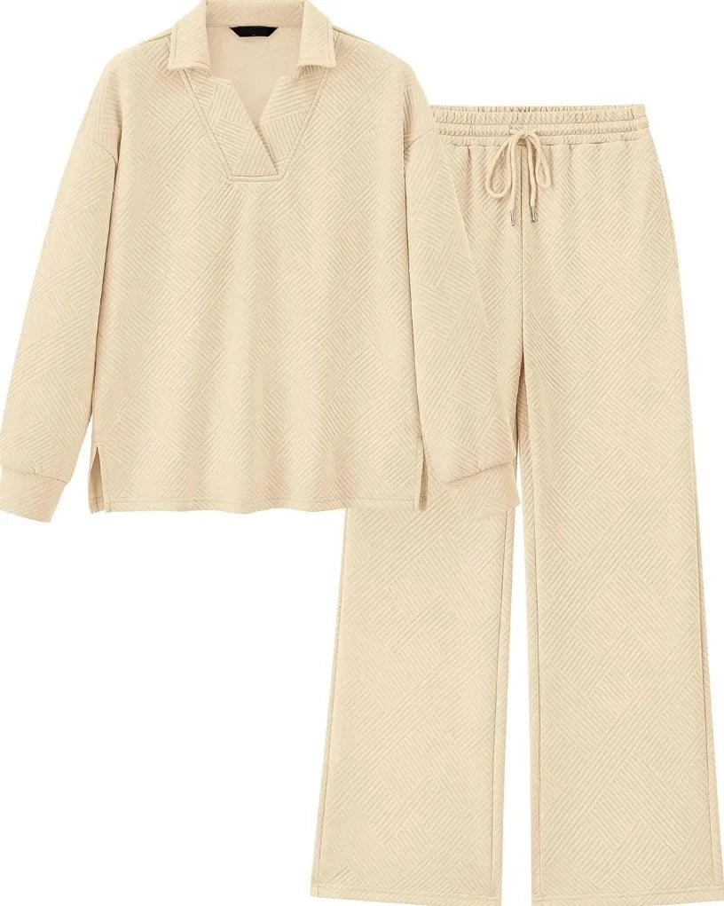 A two-piece loungewear set in a light cream color with a subtle textured pattern, featuring a long-sleeve polo-style top and matching wide-leg pants with an elastic drawstring waist.