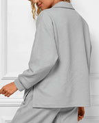 Person wearing a gray textured coat against a white background