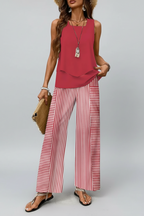 Woman wearing a red top and red and white striped pants against a neutral background