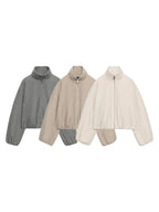Three cropped quarter-zip jackets in heather gray, beige, and cream, arranged side-by-side on a plain white background.