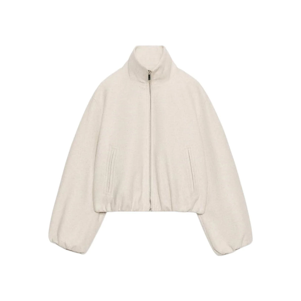 A cropped, long-sleeve zip-up jacket in a light cream or off-white color, featuring a stand-up collar, front zipper, and side pockets, shown against a plain white background.