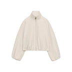 A cropped, long-sleeve zip-up jacket in a light cream or off-white color, featuring a stand-up collar, front zipper, and side pockets, shown against a plain white background.