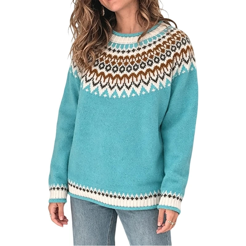 A woman wearing a turquoise long-sleeve knit sweater with a brown, white, and black geometric Fair Isle yoke pattern and matching patterned cuffs and hem, paired with light blue jeans against a white background.