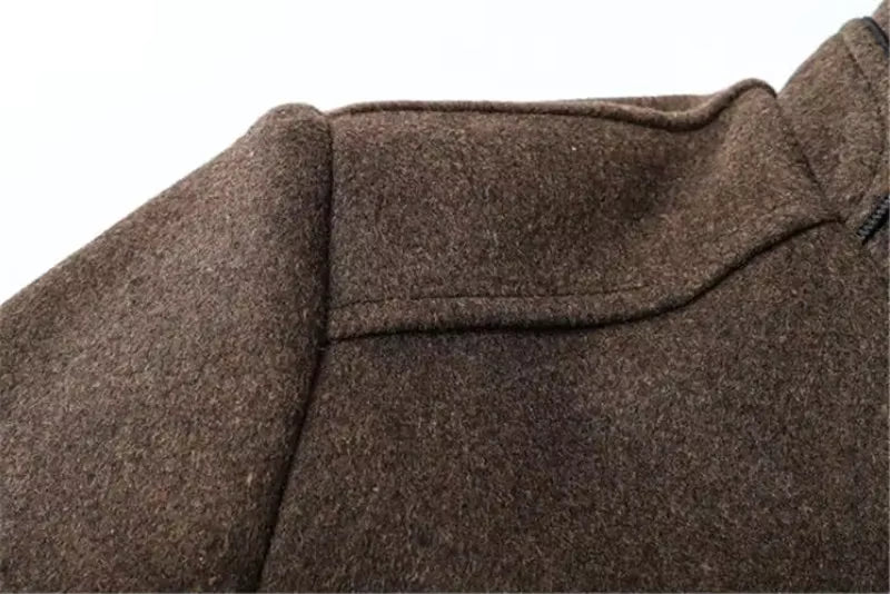 Close-up of a brown textured wool or felt garment, showing the fabric weave and collar area against a plain white background.