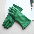 Green gloves on a light surface with a blurred background
