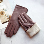 Pair of brown leather gloves with beige lining on a textured surface