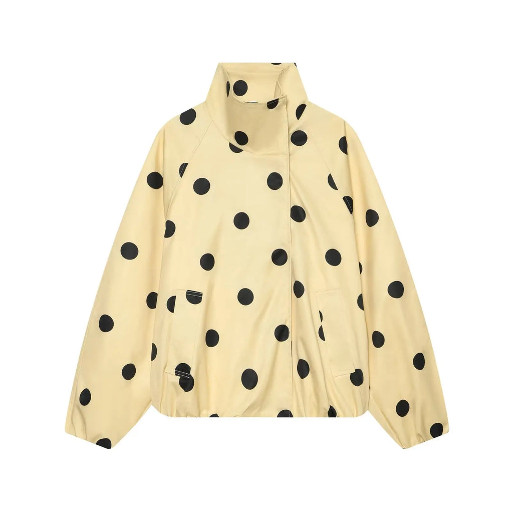 A cream-colored lightweight jacket with a black polka dot pattern, featuring a stand-up collar and front zipper closure, shown against a plain white background.
