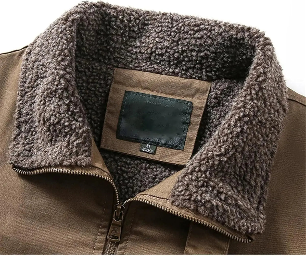 Close-up of a brown jacket with a thick, plush brown sherpa fleece collar and a front zipper, showing a blank brand patch on the inside neck.