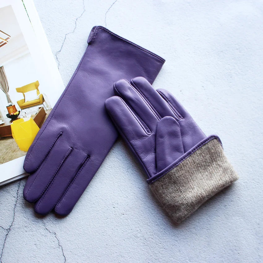 Purple gloves with a gray cuff on a light blue surface