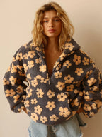 Woman wearing a floral patterned jacket against a beige background