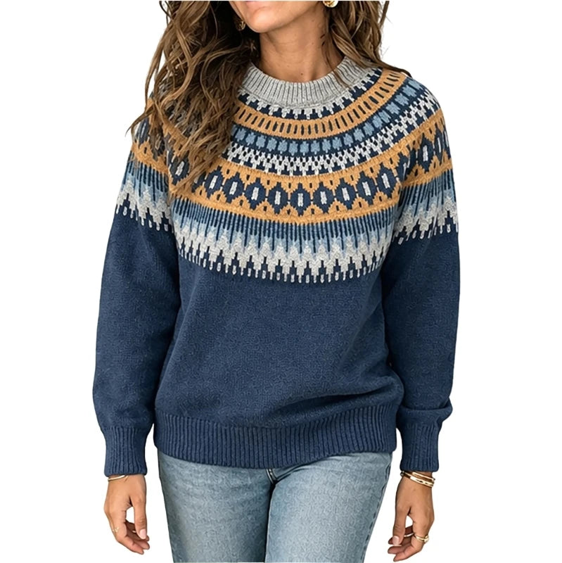 A woman wearing a navy blue knit sweater with a multicolor Fair Isle yoke pattern in blue, beige, and white, paired with light-wash jeans against a plain white background.
